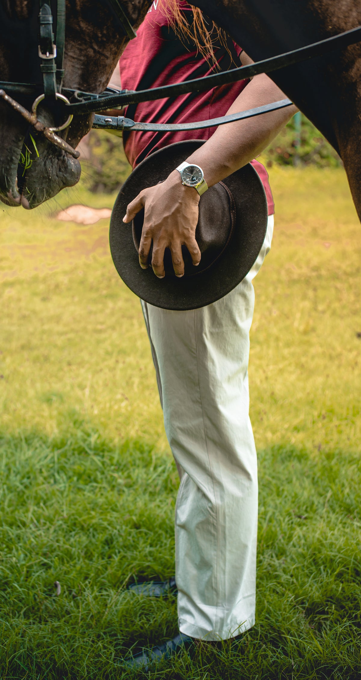LORËVEN Fold Stretch Trouser in Chalk White — man in a red shirt standing beside a horse on grass, holding a dark wide-brim hat